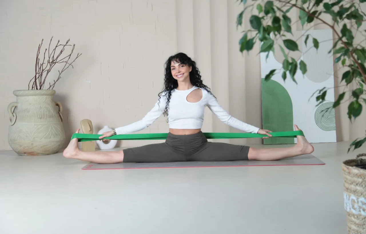Woman on an exercise mat at home holding a resistance band