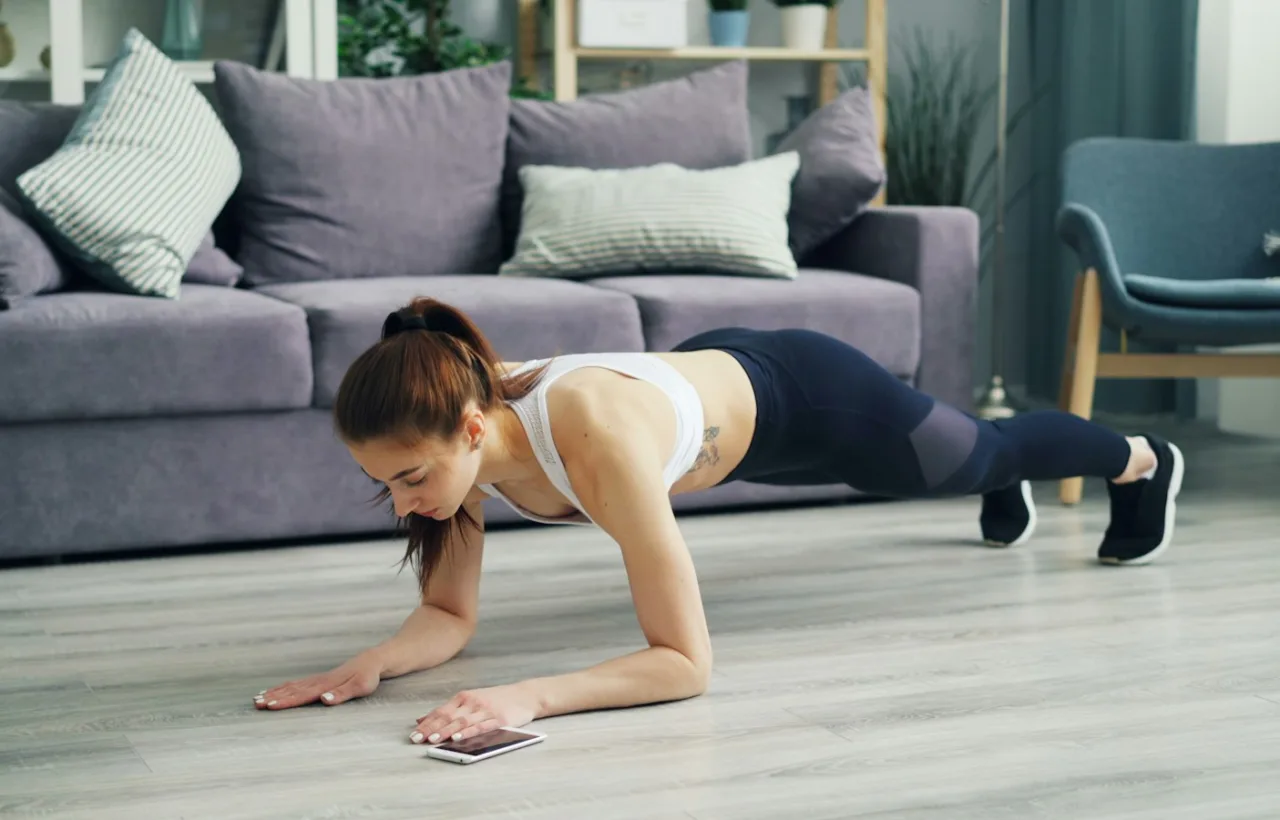 Woman doing a push-up on the floor of a living room