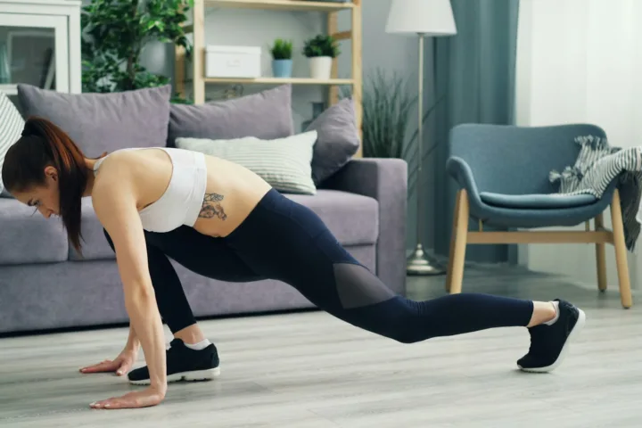 Woman doing a bodyweight exercise on a mat in her living room