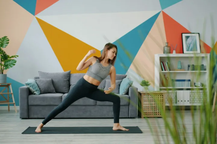 Woman exercising on a mat in a colourful living room