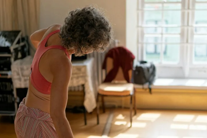 Older woman stretching gently in a sunlit room