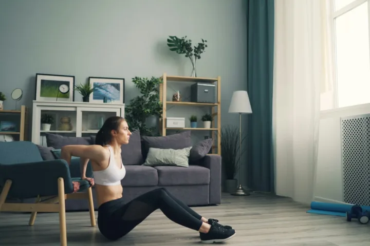 Woman doing a leg exercise on the floor of her living room
