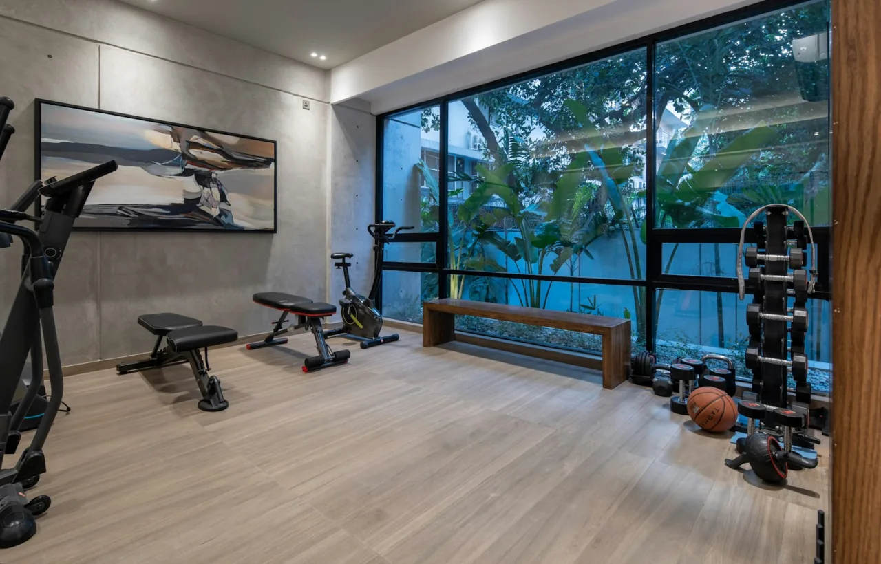 Bright home gym with strength equipment and large windows
