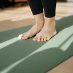 Bare feet standing on a yoga mat, ready to start a first home workout