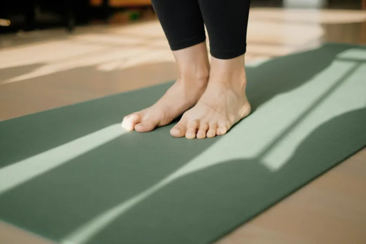 Bare feet standing on a yoga mat, ready to start a first home workout
