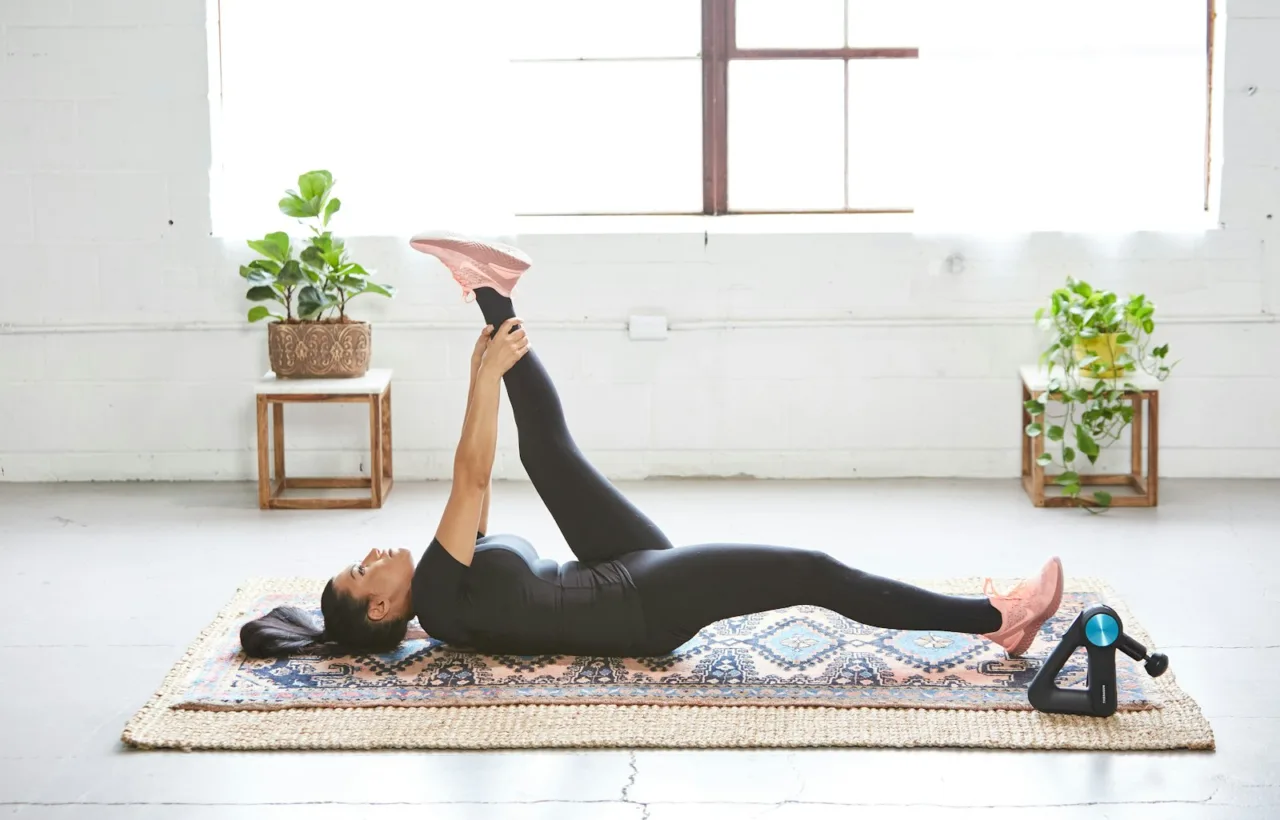 Woman lying on an exercise mat at home doing a leg raise